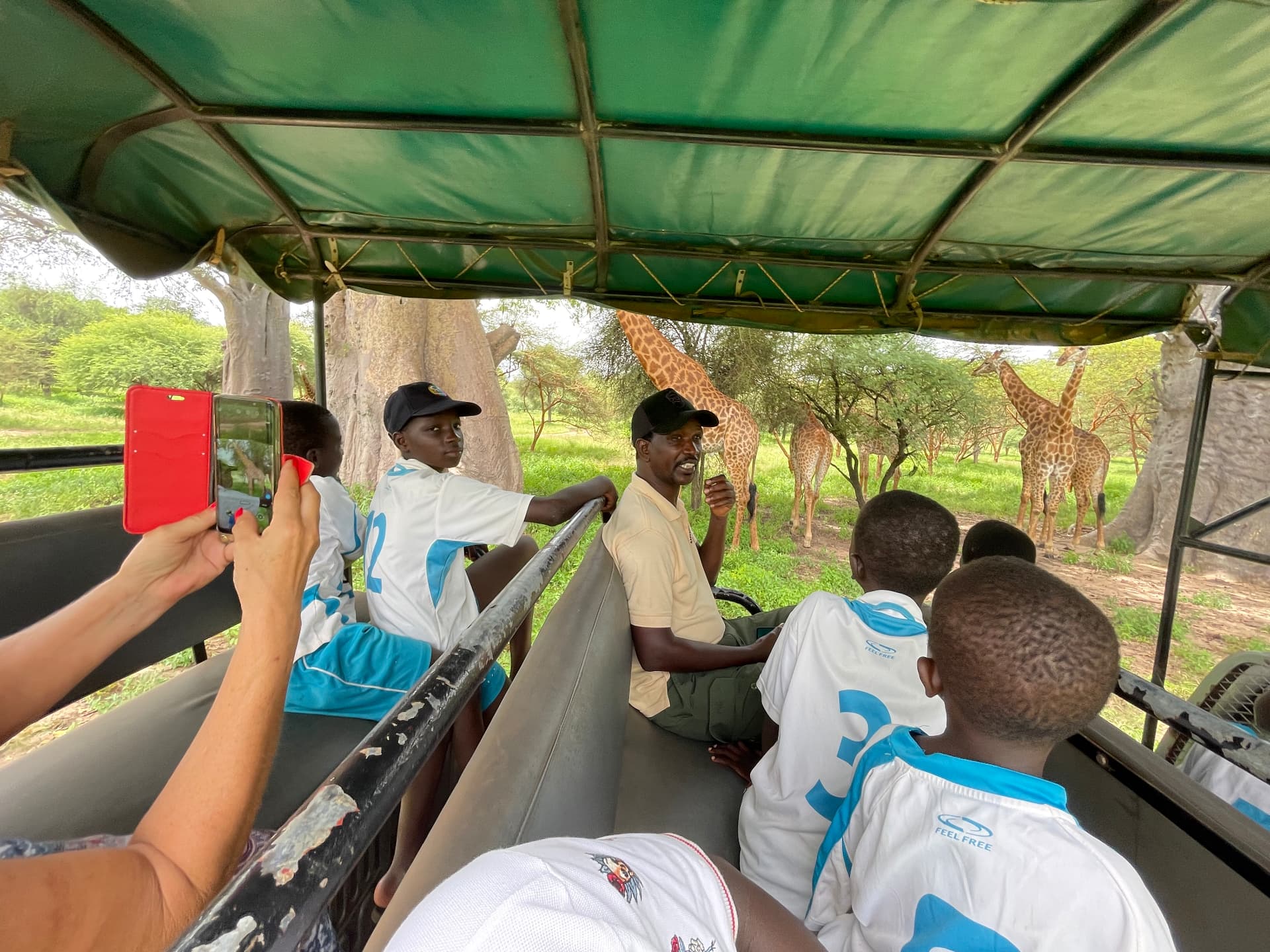 Enfants observant des girafes depuis un véhicule de safari à la Réserve de Bandia