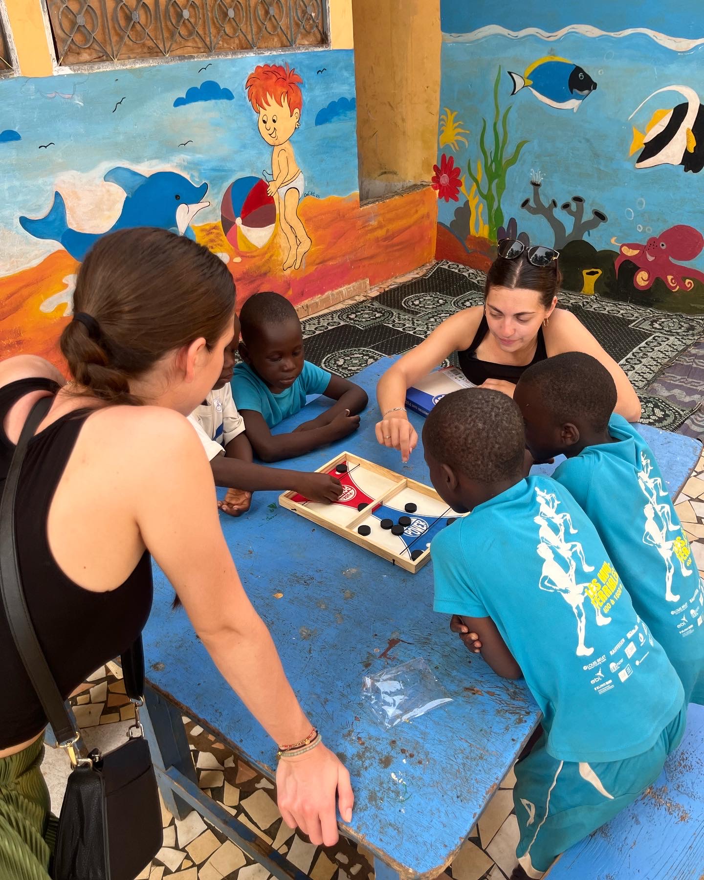 Bénévoles jouant à un jeu de société avec des enfants