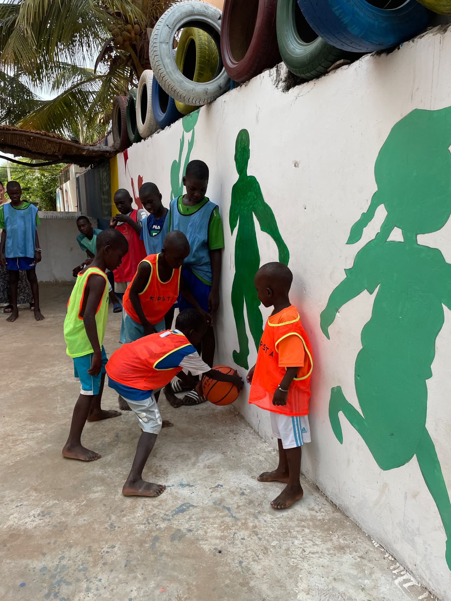 Enfants en chasubles colorées avec un ballon de basket
