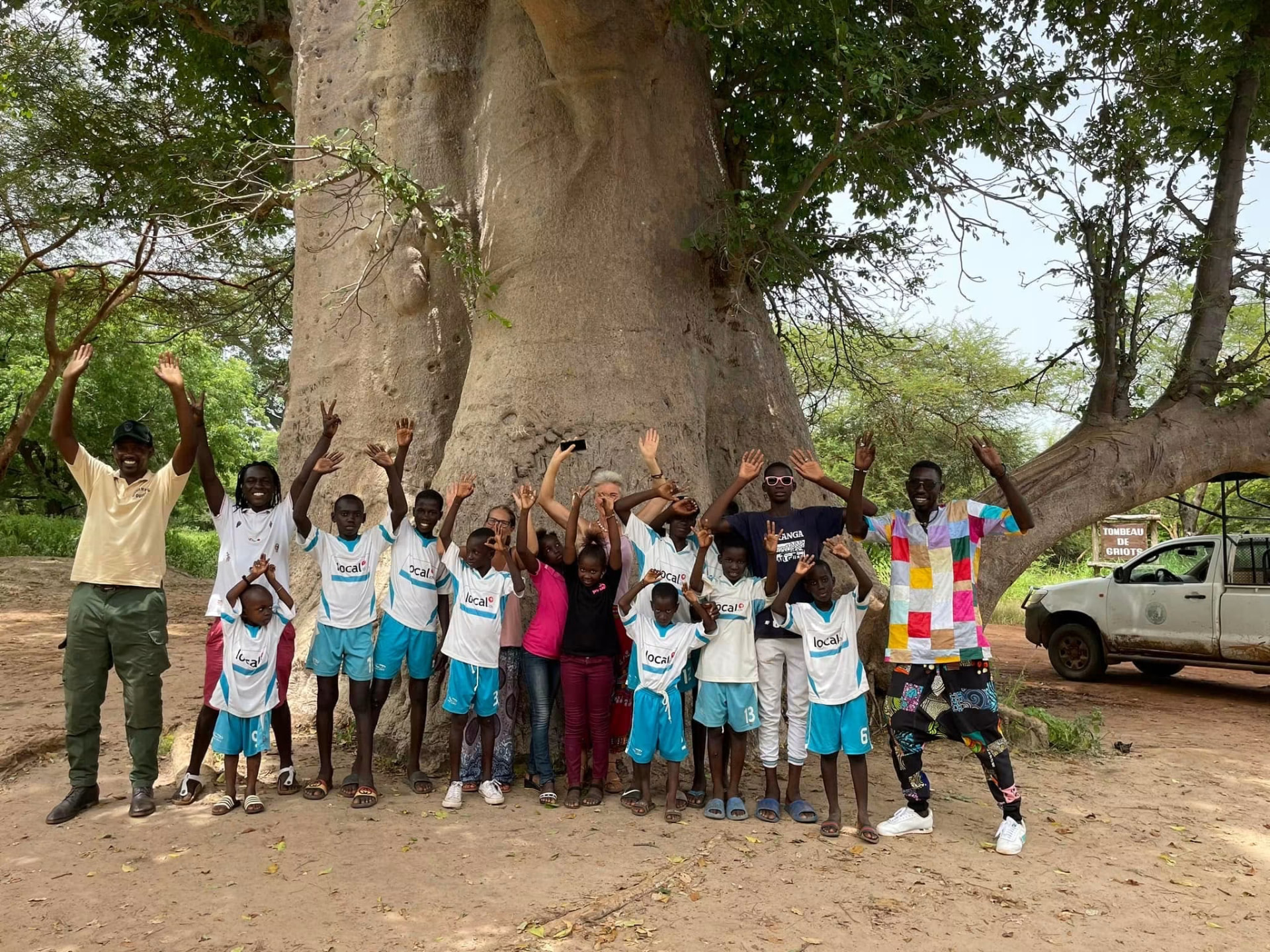 Groupe d'enfants et d'encadrants devant un baobab géant de la Réserve de Bandia