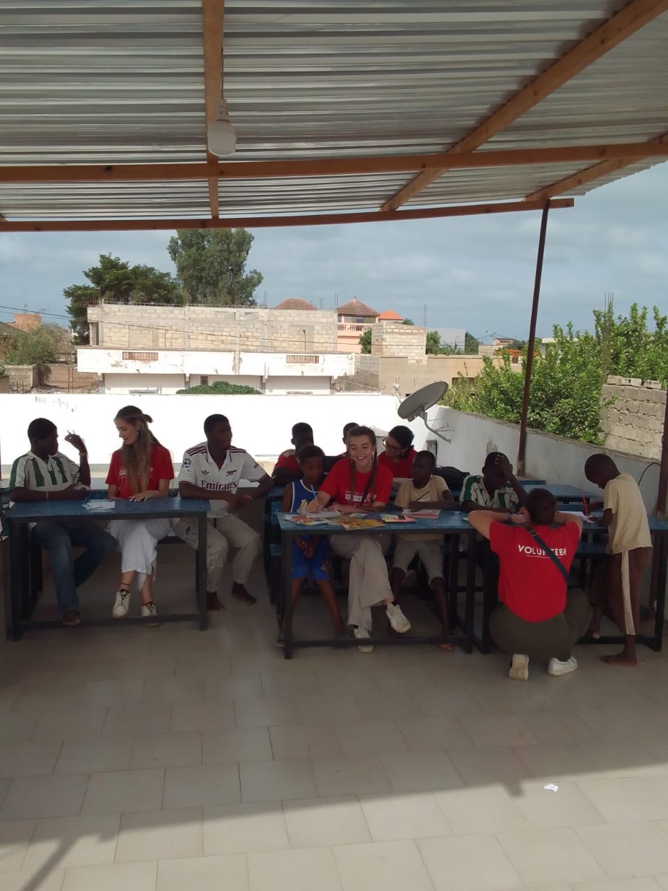 Enfants et bénévoles travaillant ensemble sur les tables de la terrasse