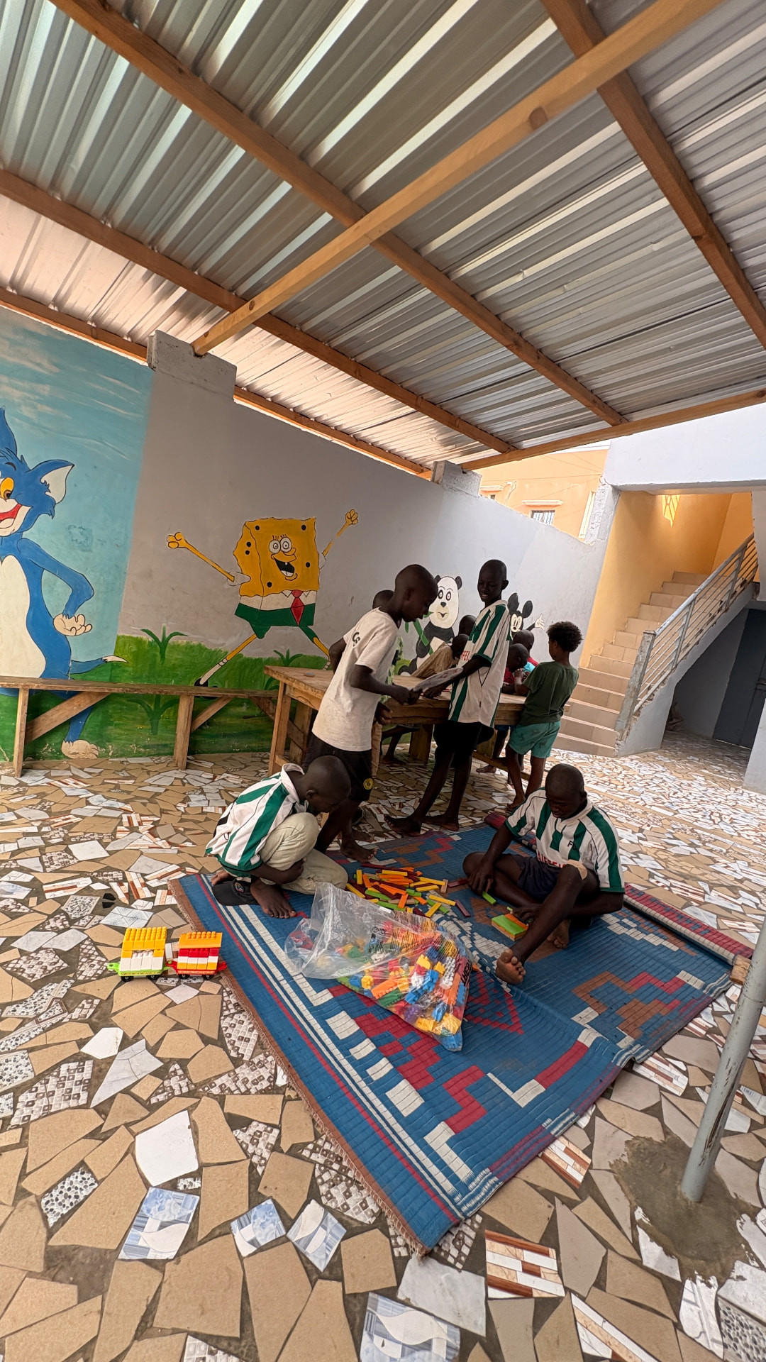 Enfants jouant avec des briques de construction sous le préau