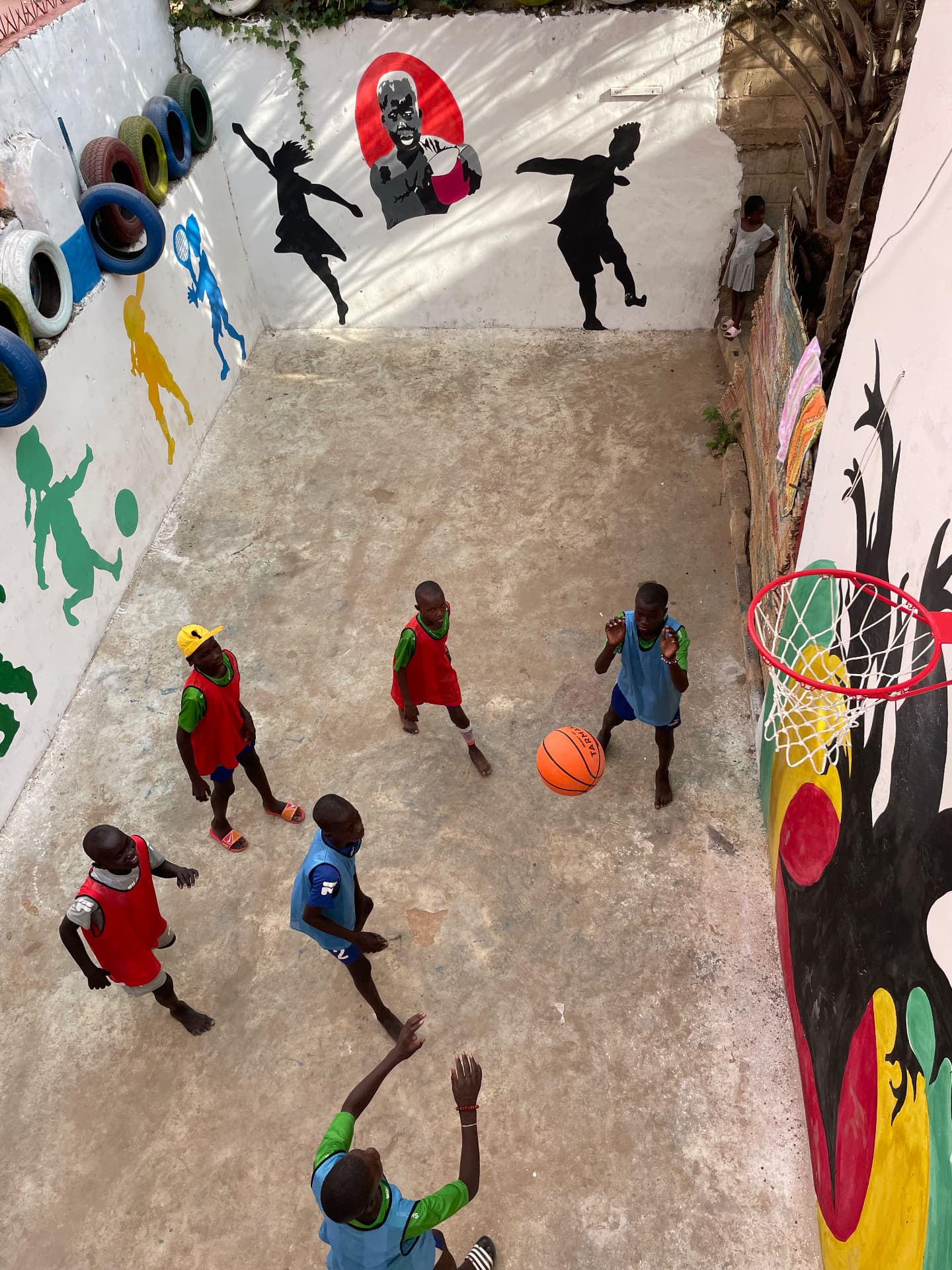 Enfants jouant au basket dans la cour peinte du centre