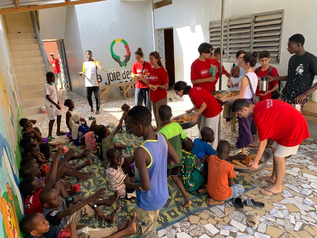Bénévoles distribuant du pain et des boissons aux enfants