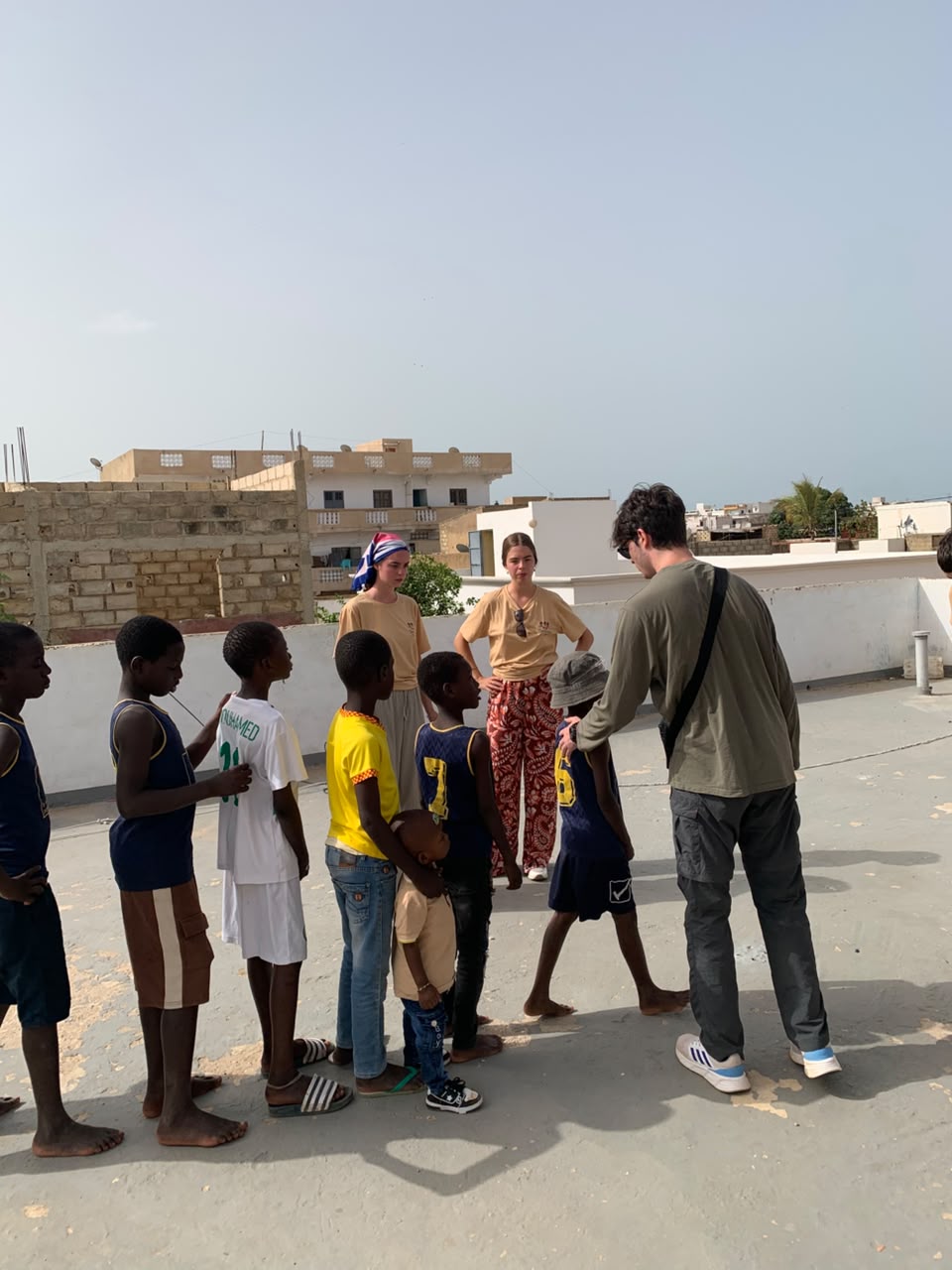 Bénévoles encadrant les enfants sur la terrasse du centre avant une activité